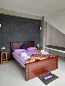 纳拉坦尼亚Water Side Guest的一间卧室配有一张带紫色床单和紫色枕头的床