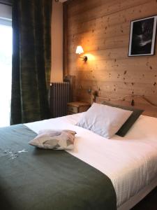 热拉梅Le Ptit Hotel du Lac的一间卧室设有一张带木墙的大床