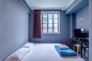 新加坡K Hotel 14的一间卧室配有一张带窗户的床和一台电视