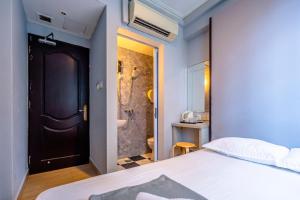 新加坡K Hotel 14的一间卧室配有一张床,浴室设有淋浴。