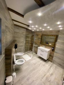 拉克塔希Motel pizzeria Antic's的浴室配有2个盥洗盆、卫生间和淋浴。