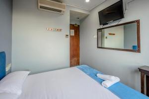 新加坡K Hotel 1515的一间卧室配有一张带镜子的床和一台电视
