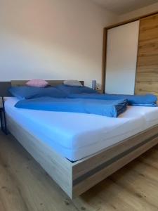 绍滕斯Leonies Appartement的一间卧室配有一张带蓝色枕头的大床
