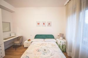 科尔恰诺B&B Il Girasole的白色卧室配有床和书桌