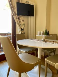 罗卡拉索Casa Montagne的一间配备有白色桌椅的用餐室