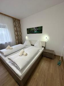RoppenPension Alpina的一间卧室配有两张带白色床单的床