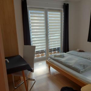 陶普利茨Haus Mundl的卧室配有床、椅子和窗户。