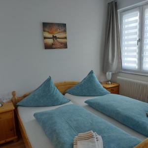 陶普利茨Haus Mundl的卧室内的两张床和蓝色枕头