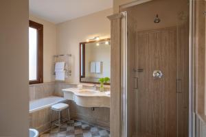 罗马莫扎特酒店的一间带水槽、浴缸和镜子的浴室