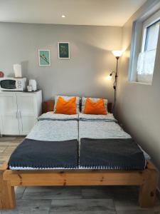 奥特朗Charmant studio á Autrans的一张带两个橙色枕头的床