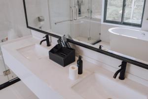 BaybayFan's Hotel的白色的浴室设有两个盥洗盆和镜子