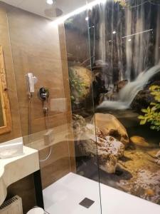 埃尔毛Alte Post的浴室内装有瀑布壁画,配有淋浴