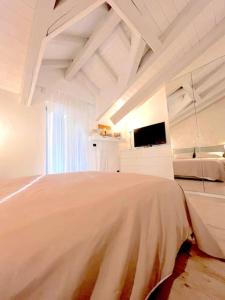 奥斯塔Grazioso appartamento Aosta的一间白色卧室,配有一张大床和一台电视