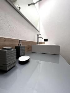 奥斯塔Grazioso appartamento Aosta的白色的浴室设有水槽和镜子
