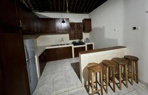 JarakanDream Village的厨房配有木制橱柜和带凳子的台面