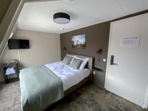 卡茨休维尔Hotel de Slapende Hollander的一间带一张床铺的卧室,位于带天花板的房间内