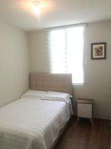 皮乌拉Departamento de estreno en 1er piso en Condominio的卧室配有白色的床和窗户。