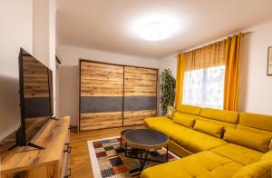 赛尔斯贝格DieLangthalers Exklusive Oase的客厅设有黄色沙发和电视