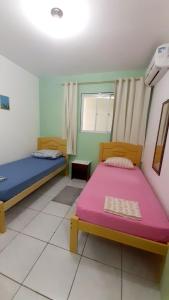 弗洛里亚诺波利斯Pousada Mar Verde的客房设有两张床和窗户。