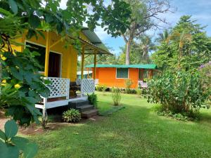 托尔图格罗All Rankins Eco-Lodge的院子里设有长凳的黄色和橙色房子