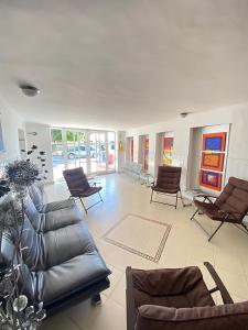 里奥阿查Hotel La Guajira的客厅配有真皮沙发和椅子