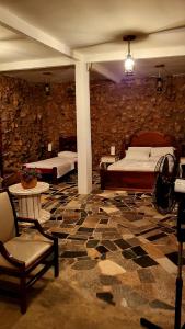 PlanaltinaFazenda Hotel Bem Ecológico的一间设有两张床和石墙的房间