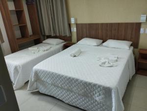 嘎林海斯港Pousada Casarão do Porto - Porto de Galinhas PE的两张位于酒店客房的床,配有毛巾