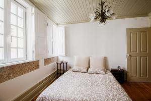 维塞乌Casa da Judiaria Velha的一间卧室配有带两个枕头的床和窗户