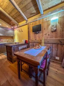 格雷桑La Buca delle Fate的一间带木桌和电视的用餐室