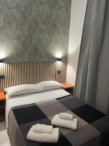 罗马装饰艺术酒店的一间卧室配有一张床,上面有两条毛巾