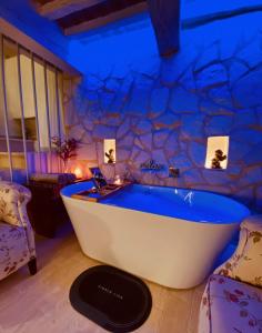托迪Vermaaten Boutique Suites Diamond的石墙客房内的浴缸