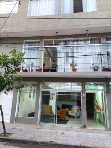 塔里哈Hotel Apartamentos "Dominó"的一座带玻璃门和阳台的建筑