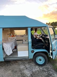 波尔蒂芒Rent a BlueClassics 's campervan vw T3 in Algarve au Portugal,的坐在蓝色面包车后面的女人