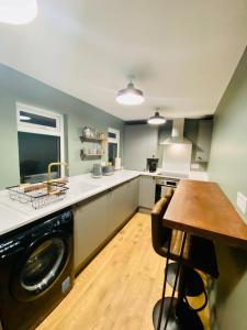 毕晓普奥克兰The Etherley - Zillo的厨房配有洗衣机和木桌。