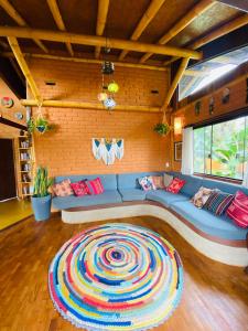 戈亚斯州上帕莱索Casa Lobo-guará的客厅配有蓝色的沙发和色彩缤纷的地毯。
