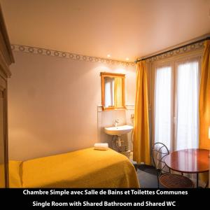 巴黎Port Royal Hotel的一间卧室配有一张床、一张桌子和一面镜子
