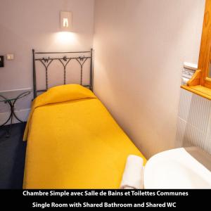 巴黎Port Royal Hotel的一间卧室配有黄色的床和黄色的毯子