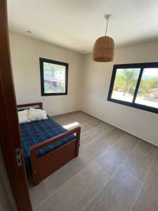 耶尔瓦布埃纳Casa en Country的一间卧室设有一张床和两个窗户。