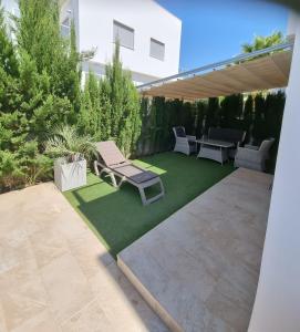 阿利坎特Marinamed Residential的庭院设有草坪、长凳和桌子。