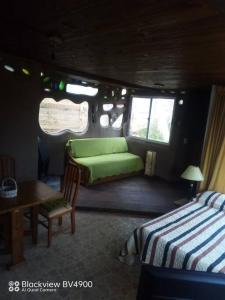 萨利纳斯Casita entre dunas al son del mar的客房设有两张床、一张桌子和一张沙发。