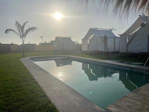 利马AMAY的一座游泳池,位于一个拥有房屋和阳光的庭院内