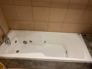 达卡卫Casa Centro Dalcahue的浴室设有白色浴缸,浴室设有瓷砖墙