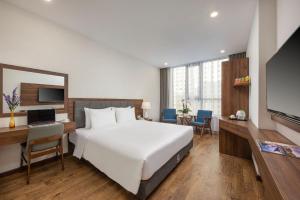 岘港Capecia Danang Hotel and Apartment的酒店客房设有一张白色大床和一张书桌