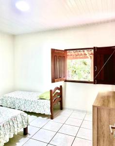 特里温福Casa do Pôr do Sol的客房设有两张床和窗户。