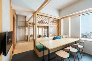 熊本OMO5 Kumamoto by Hoshino Resorts的客房设有桌椅和大窗户。