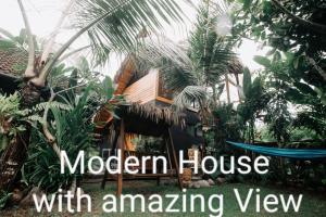 普卢坎Ayumar Homestay Medewi的现代房屋享有树木和植物的壮丽景色