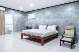 Ban Bo HanGuesthouse Phuket Airport的一间卧室配有一张床和一把椅子