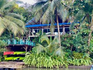 La ViñaPalmeras del Río HOTEL的热带房屋 - 带蓝色甲板和棕榈树