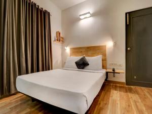 班加罗尔Upar Hotels Indiranagar的卧室设有一张白色大床和一扇窗户。