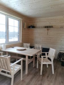 叶尔加瓦''Ābeļdārzs''的一间带木桌和椅子的用餐室